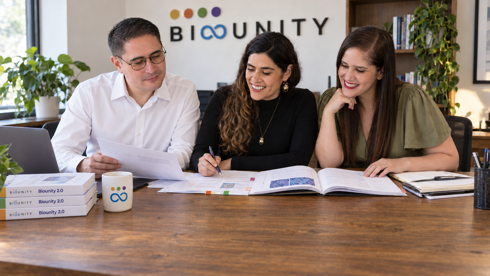 Diana, Rodrigo y Alejandra reunidos alrededor de una mesa, revisando los libros y compendios de Biounity.